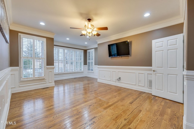 unfurnished living room with ornamental molding, ceiling fan, light wood finished floors, and visible vents