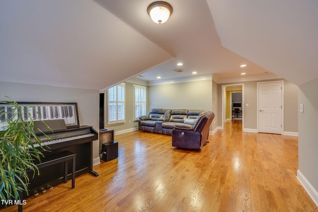 living room with light wood finished floors, baseboards, crown molding, and recessed lighting