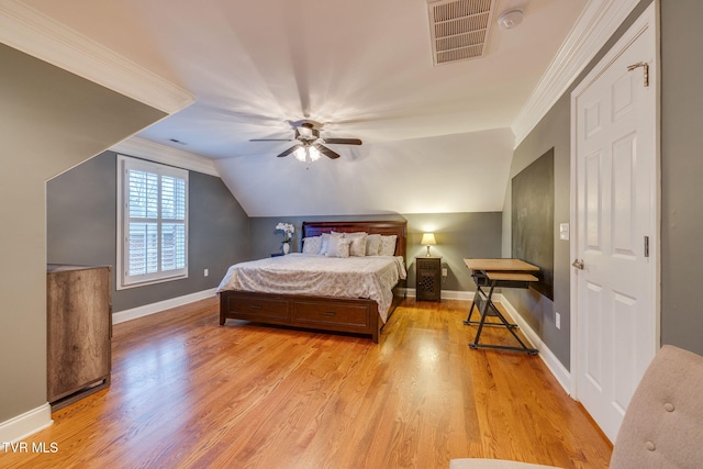 bedroom with baseboards, light wood-style flooring, visible vents, and crown molding