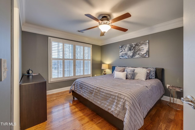 bedroom featuring ornamental molding, a ceiling fan, baseboards, and wood finished floors