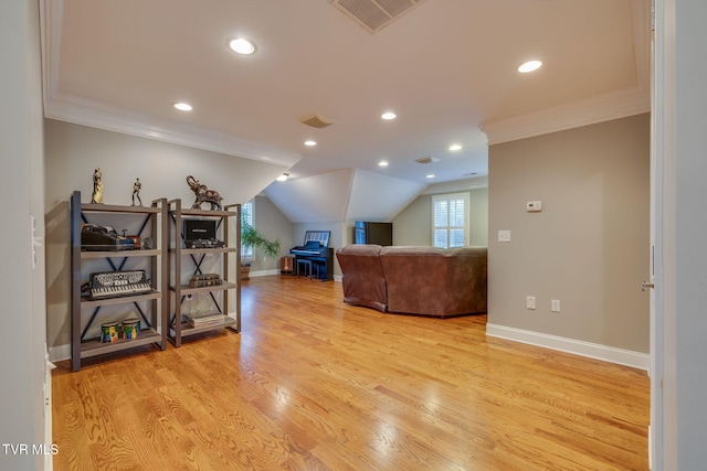 living area with ornamental molding, visible vents, light wood-style floors, and baseboards