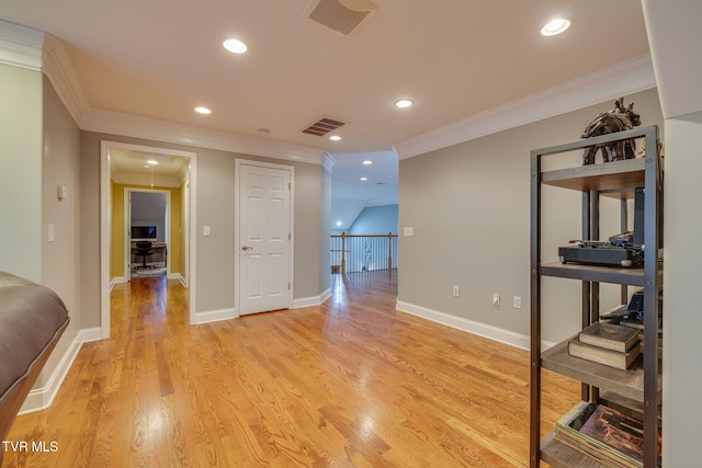 interior space featuring light wood finished floors, visible vents, and crown molding