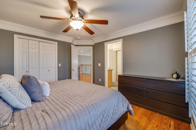 bedroom featuring crown molding, a closet, connected bathroom, ceiling fan, and light wood-type flooring