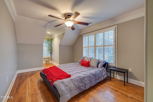 bedroom with baseboards, crown molding, and wood finished floors