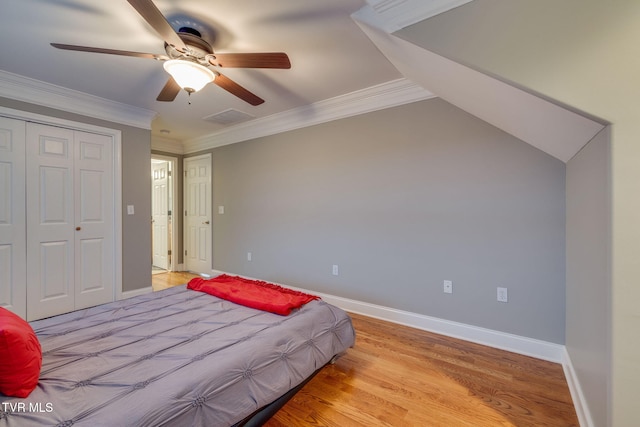 bedroom featuring visible vents, baseboards, a ceiling fan, light wood-style flooring, and ornamental molding