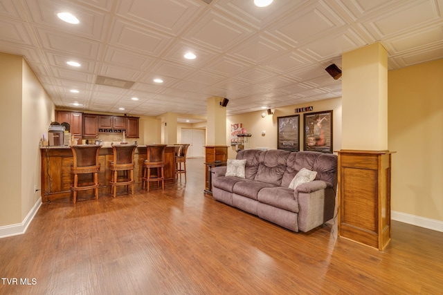 living area with light wood finished floors, wet bar, baseboards, and recessed lighting