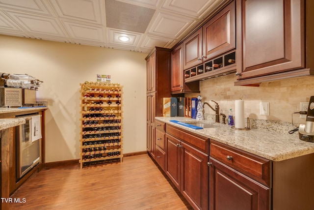 wine cellar with an ornate ceiling, light wood-style flooring, baseboards, and a sink