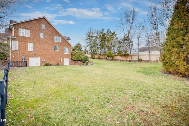 view of yard featuring a garage and a fenced backyard