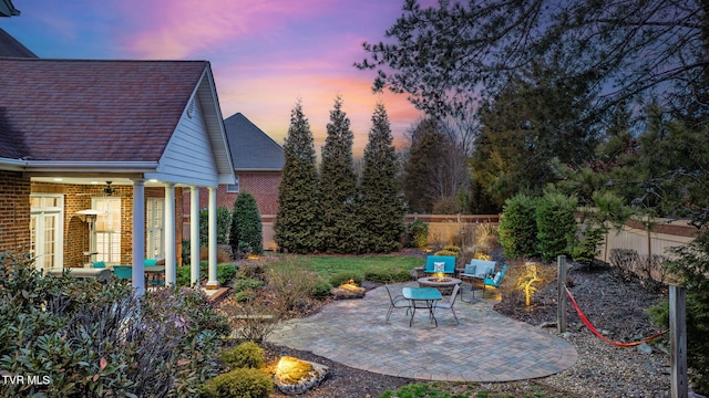 yard at dusk with a patio area, a fenced backyard, and an outdoor hangout area