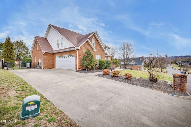 view of side of home featuring a garage, concrete driveway, brick siding, and fence