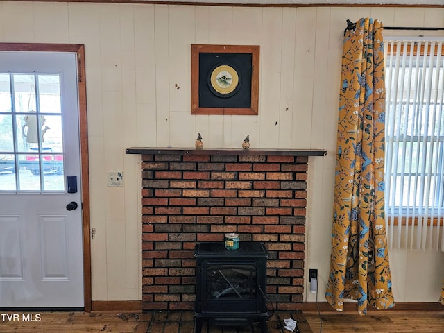 interior details with a wood stove and wood-type flooring