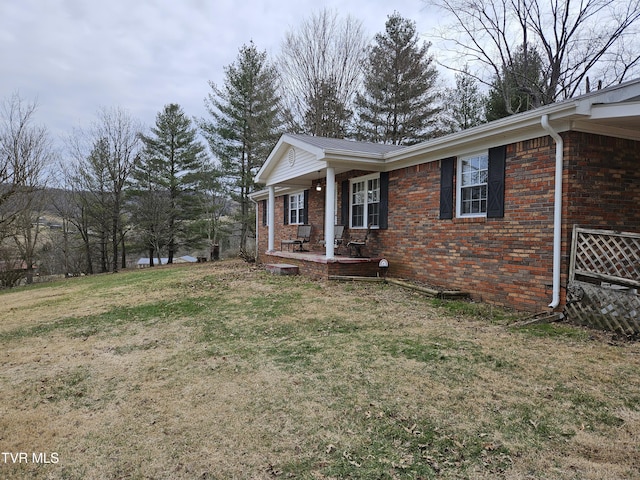 view of home's exterior with covered porch and a yard