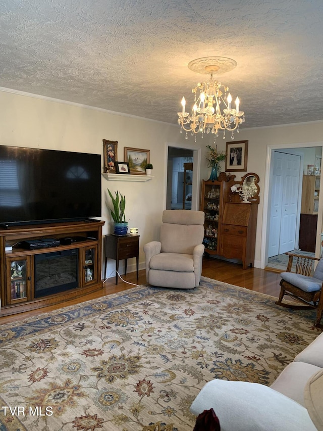 living room featuring a textured ceiling, an inviting chandelier, and hardwood / wood-style flooring