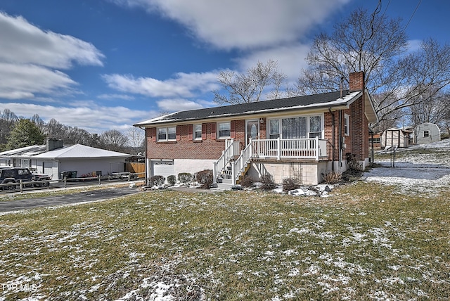 view of front of property featuring a lawn, a chimney, aphalt driveway, an attached garage, and brick siding