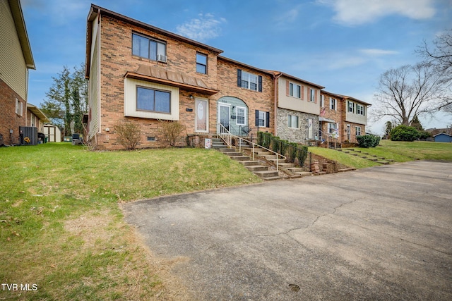 multi unit property featuring brick siding and a front lawn