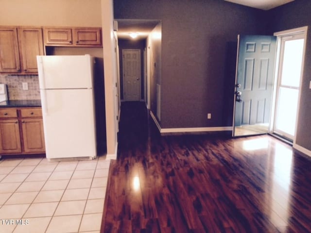 kitchen with backsplash, white fridge, and light tile patterned floors