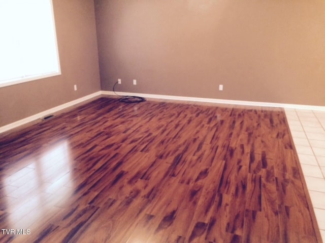 unfurnished room with wood-type flooring