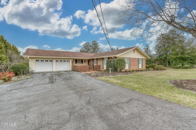 single story home featuring brick siding, a front yard, driveway, and a garage