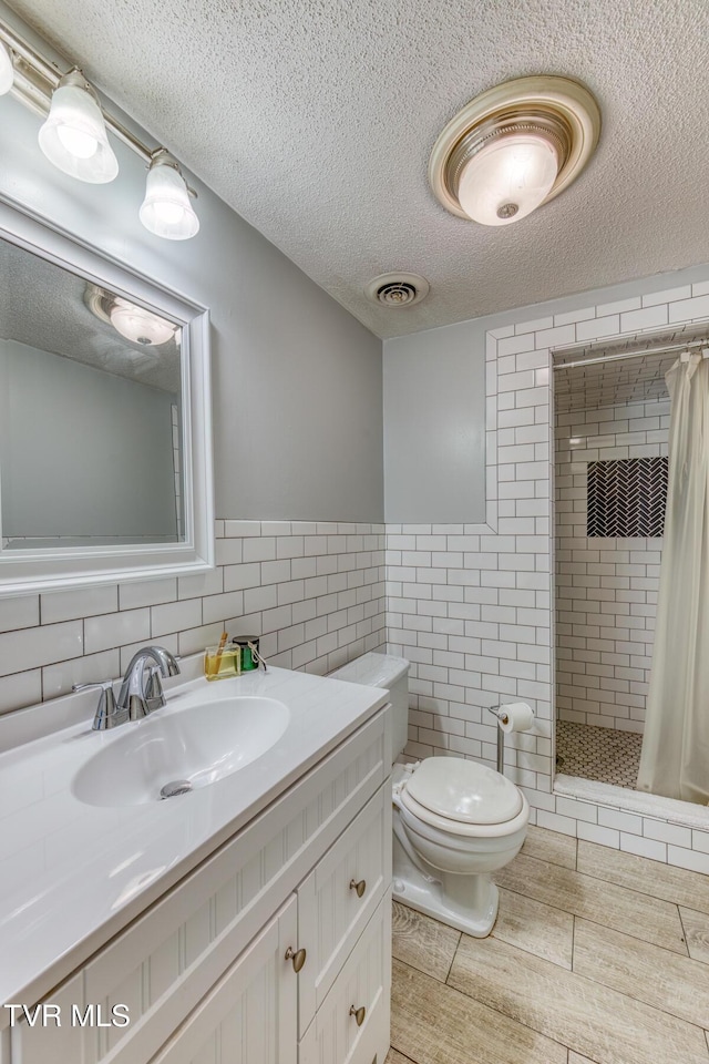 305 Overbrook Dr, Bristol, TN 37620 - full bathroom featuring tile walls, visible vents, a textured ceiling, toilet, and a shower stall