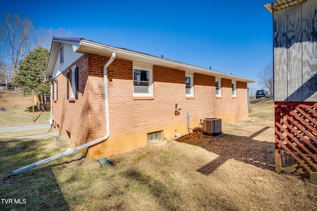 view of side of property featuring central AC unit and brick siding