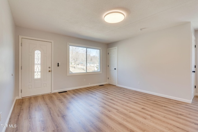 entryway with visible vents, light wood-style flooring, and baseboards