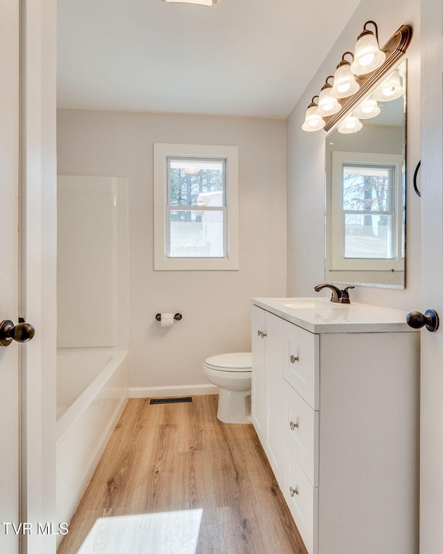 full bathroom featuring toilet, a healthy amount of sunlight, visible vents, and vanity