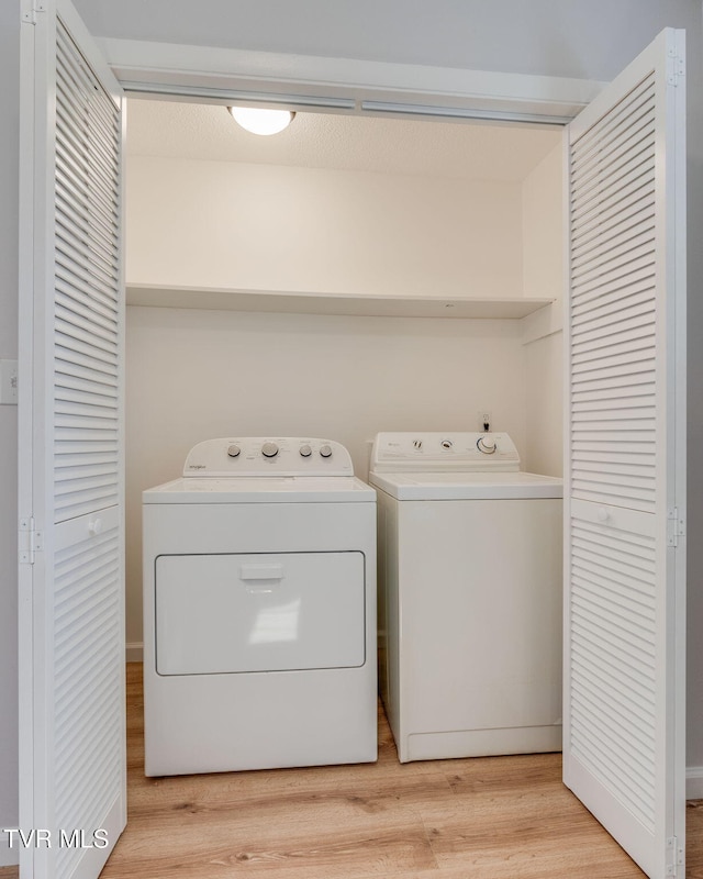 clothes washing area featuring light wood-style floors, laundry area, and independent washer and dryer