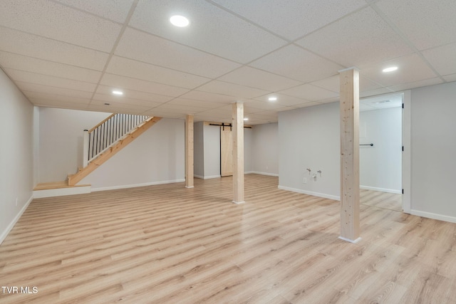 finished below grade area featuring stairs, recessed lighting, wood finished floors, and baseboards