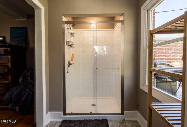 bathroom featuring baseboards, a spacious closet, and a shower stall