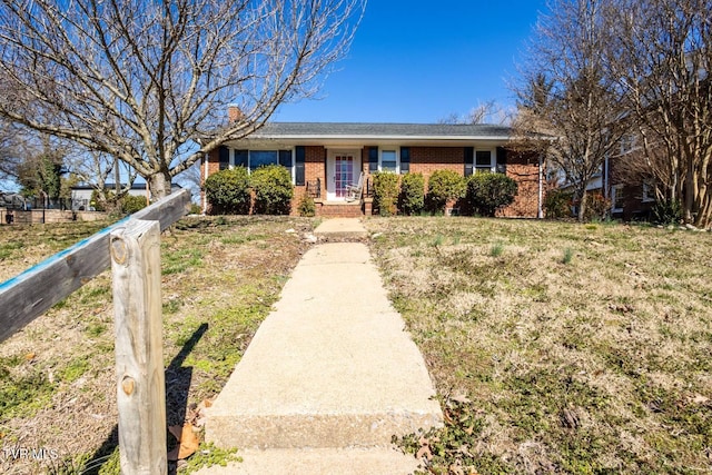 ranch-style home with brick siding, a front lawn, and fence