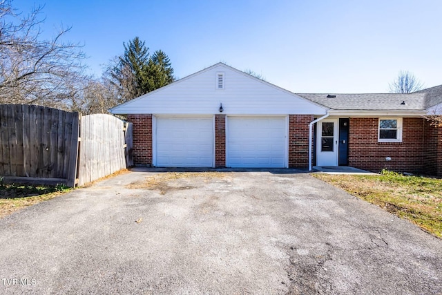 ranch-style house with a garage, a gate, aphalt driveway, and brick siding