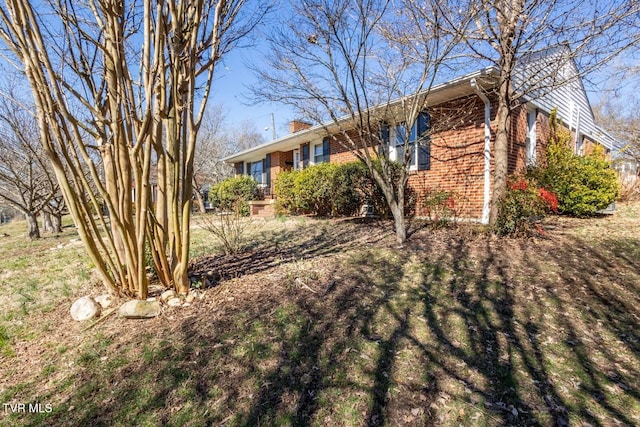 exterior space with brick siding and a chimney