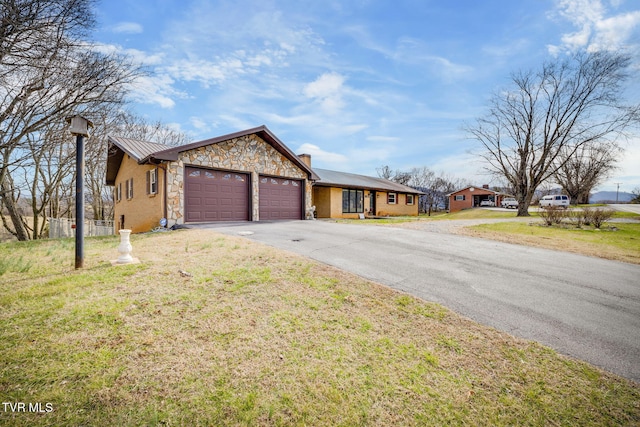 single story home featuring a front yard and a garage