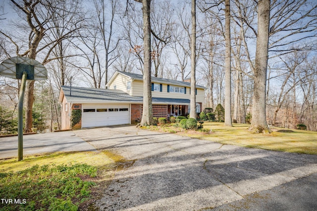 view of front of property with brick siding, driveway, a chimney, and an attached garage