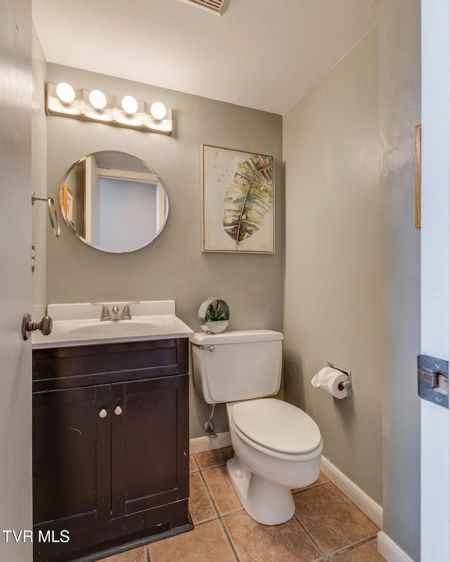 bathroom featuring toilet, tile patterned flooring, baseboards, and vanity