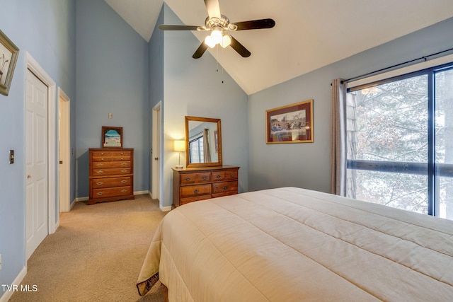 bedroom with high vaulted ceiling, light colored carpet, ceiling fan, and baseboards