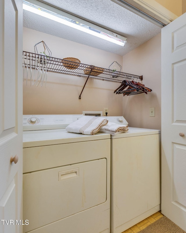 washroom with washer and dryer, laundry area, and a textured ceiling