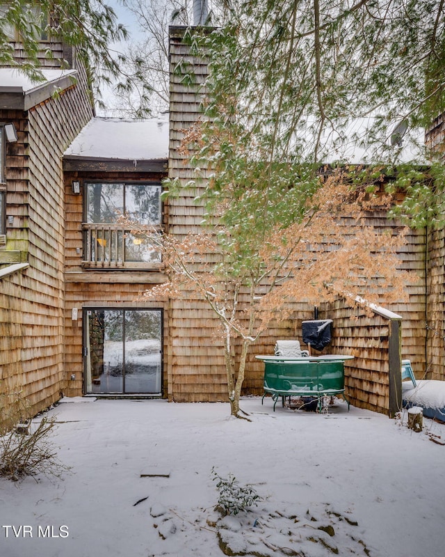 view of snow covered rear of property