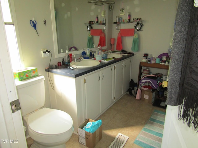 bathroom featuring visible vents, vanity, toilet, and tile patterned floors