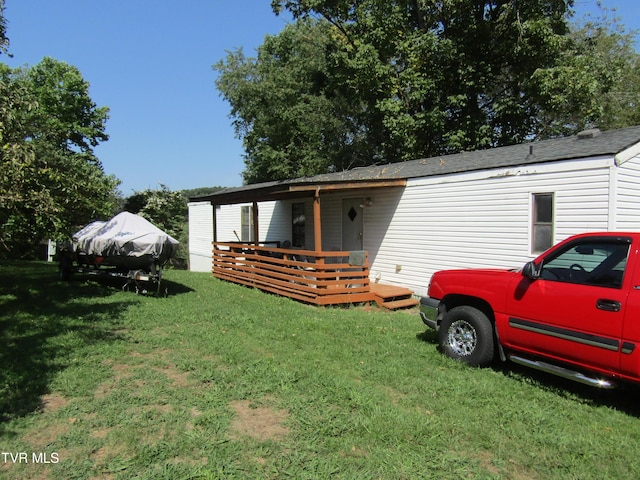 manufactured / mobile home with covered porch and a front lawn