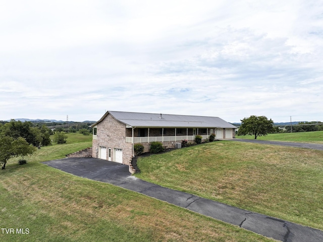 ranch-style home with an attached garage, stone siding, aphalt driveway, and a front yard