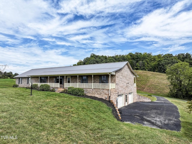 ranch-style house with a front lawn, a porch, and a garage