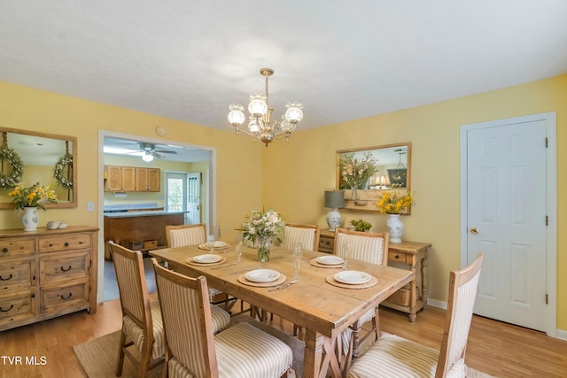 dining room with light hardwood / wood-style floors and an inviting chandelier