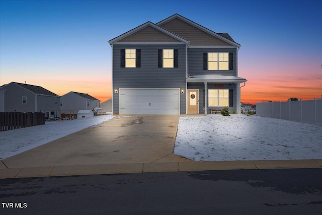 view of front of home with a garage, fence, and concrete driveway