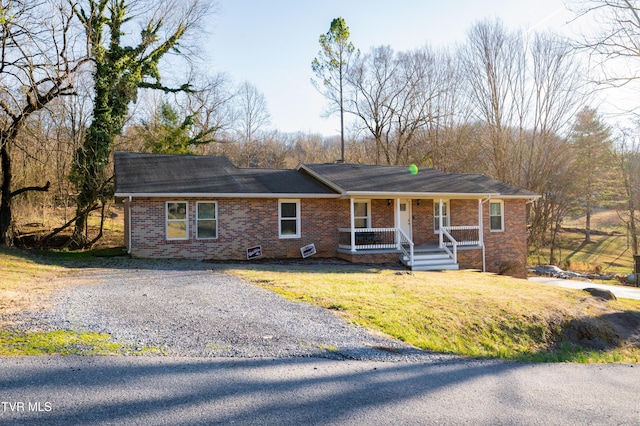 ranch-style house with a porch, a front lawn, gravel driveway, and brick siding