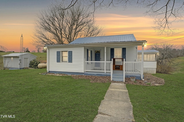 view of front of house featuring covered porch and a yard