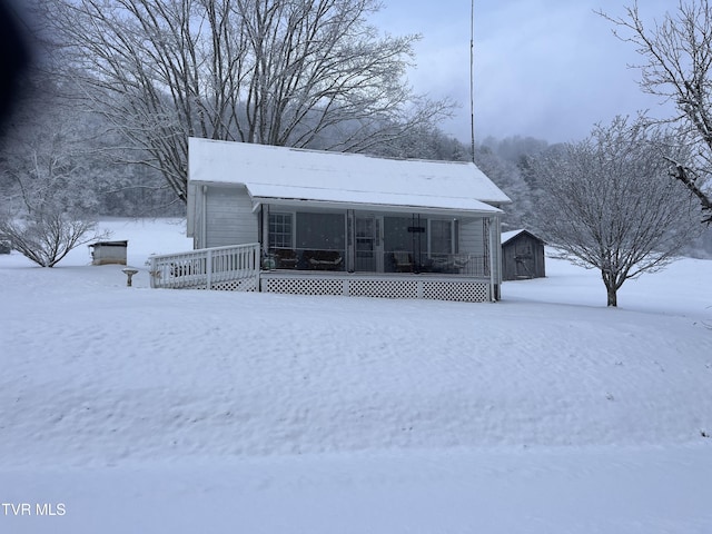 view of front facade featuring a shed, a porch, and an outdoor structure