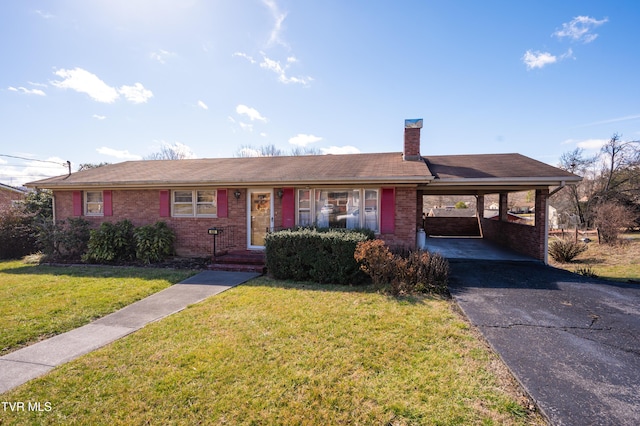 ranch-style home featuring brick siding, a chimney, a front yard, an attached carport, and aphalt driveway