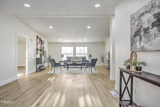 dining room featuring light wood-type flooring and a textured ceiling