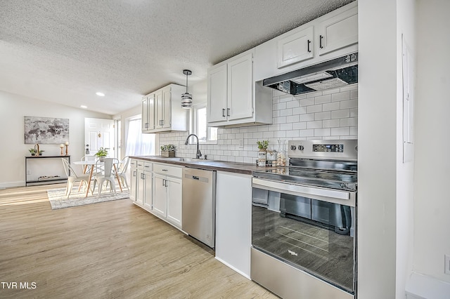 kitchen featuring white cabinets, hanging light fixtures, stainless steel appliances, and sink